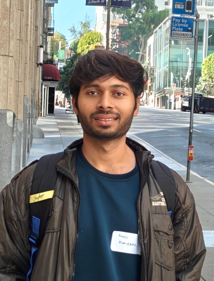 Amol S Bhalerao on a San Francisco street, smiling at the camera with a name tag on his shirt